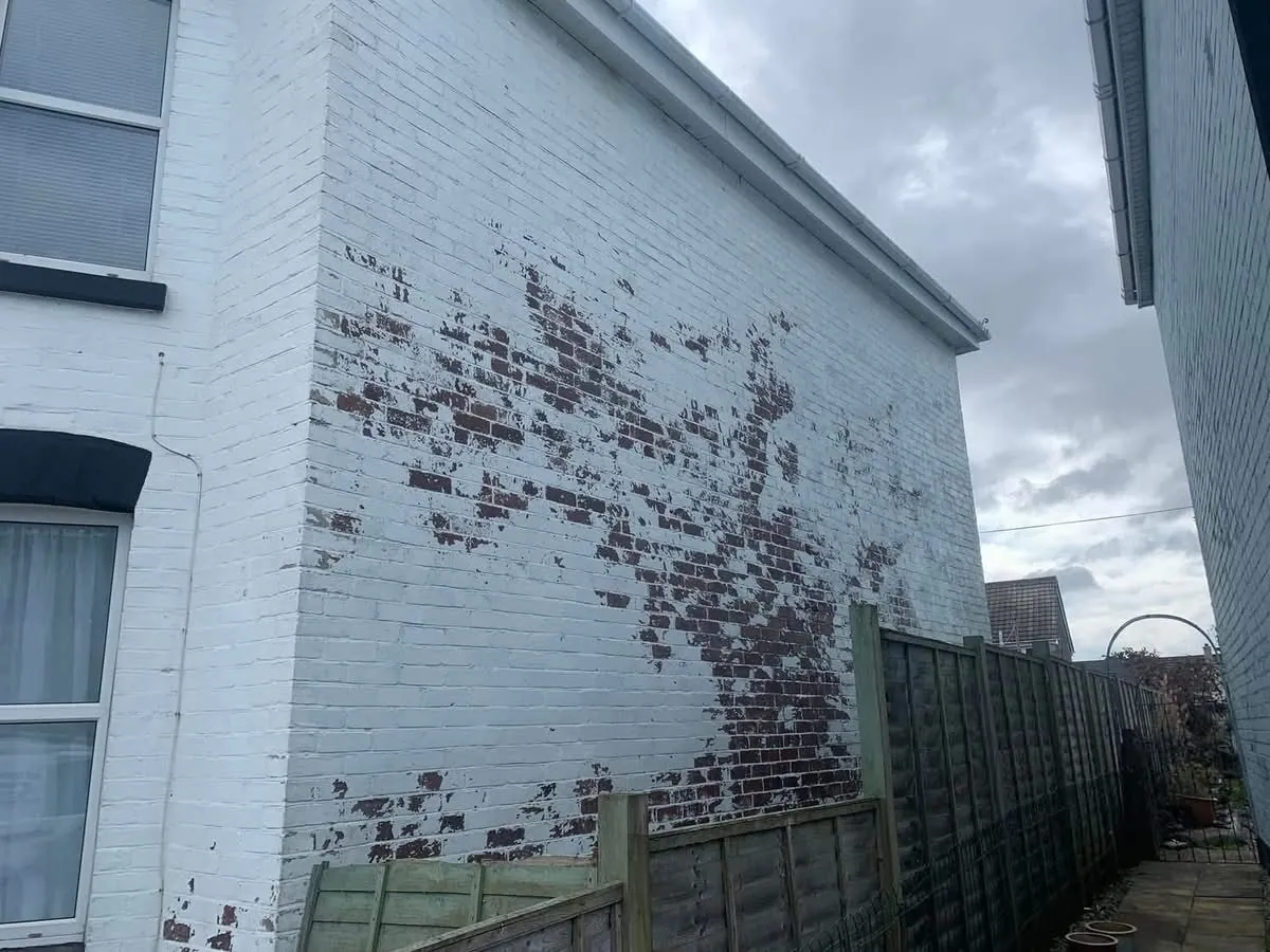Peeling paint on a brick wall before redecoration in Mullion